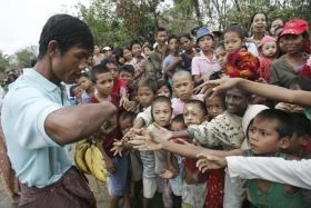 Muž z Rangúnu rozdává dětem bez přístřeší na okraji města banány.
