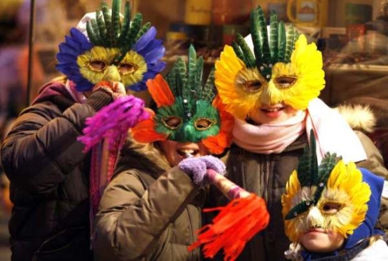Děti v Budapešti si hrají v pestrobarevných maskách.