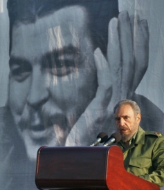 Fidel Castro během projevu v Havaně. Za ním portrét Che Guevary.