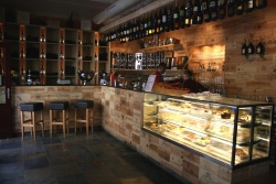 Uvnitř oslní povedený bar s desítkami aranžovaných lahví vína.