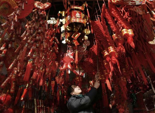 Čínská obchodnice prodává na poslední chvíli dekorace k oslavám.
