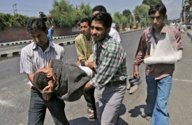 Kašmirští novináři odnášejí zraněného kolegu.
