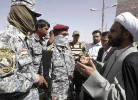 Jeden z předáků Sadrova hnutí diskutuje s iráckými vojáky.