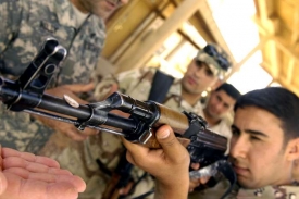 Americký voják učí střílet iráckého kolegu.