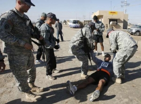 Vojáci USA pomáhají vyčerpanému kolegovi maratonci, Bagdád 12.12.08.