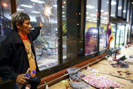 Protivládní aktivista ukazuje místo po výbuchu na bangkokském letišti.