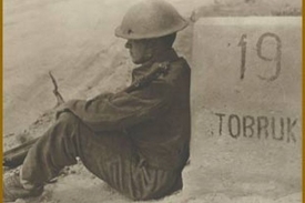 Československý voják opírající se o patník na silnici Derna-Tobruk.