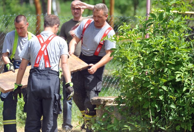 Hasiči zajišťují poklop studny. 