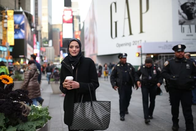 Americká muslimka a za ní policisté, New York.