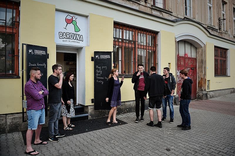 Kuřáci postávají s cigaretou před barem Barovna v Liberci .