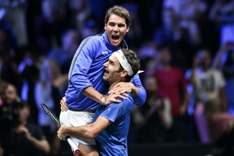 Roger Federer (vpravo) s Rafaelem Nadalem společně oslavují přelomový moment tenisové historie.