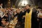 Ukrajinský kněz žehná tradičním koláčům a malovaným vajíčkům při oslavách v Kyjevě.