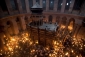 Ortodoxní křesťanští poutníci zapalují svíčky v kostele Svatého hrobu v Jeruzalémě. Právě na místě tohoto kostela měl být kdysi Ježíš ukřižován.