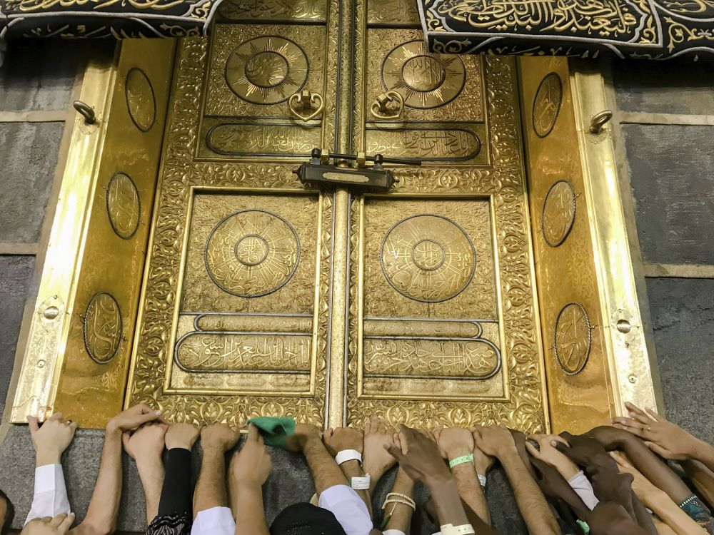 Muslimové se při motlitbách dotýkají zlatých dveří svatyně Kabu.