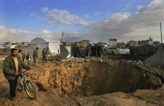 Palestinci si prohlížejí zničený pašerácký tunel po dopadu bomby.