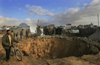 Palestinci si prohlížejí zničený pašerácký tunel po dopadu bomby.