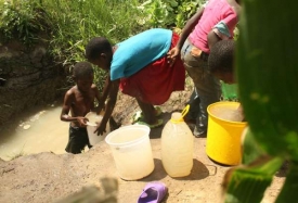 Lidé si nabírají vodu v potoce u Harare. Vodovodní řády kolabují.